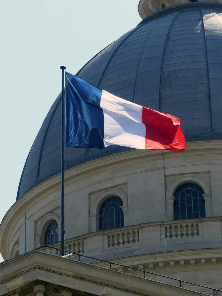 The French flag waves on a flagpole beside the Pantheon dome in Paris, France.